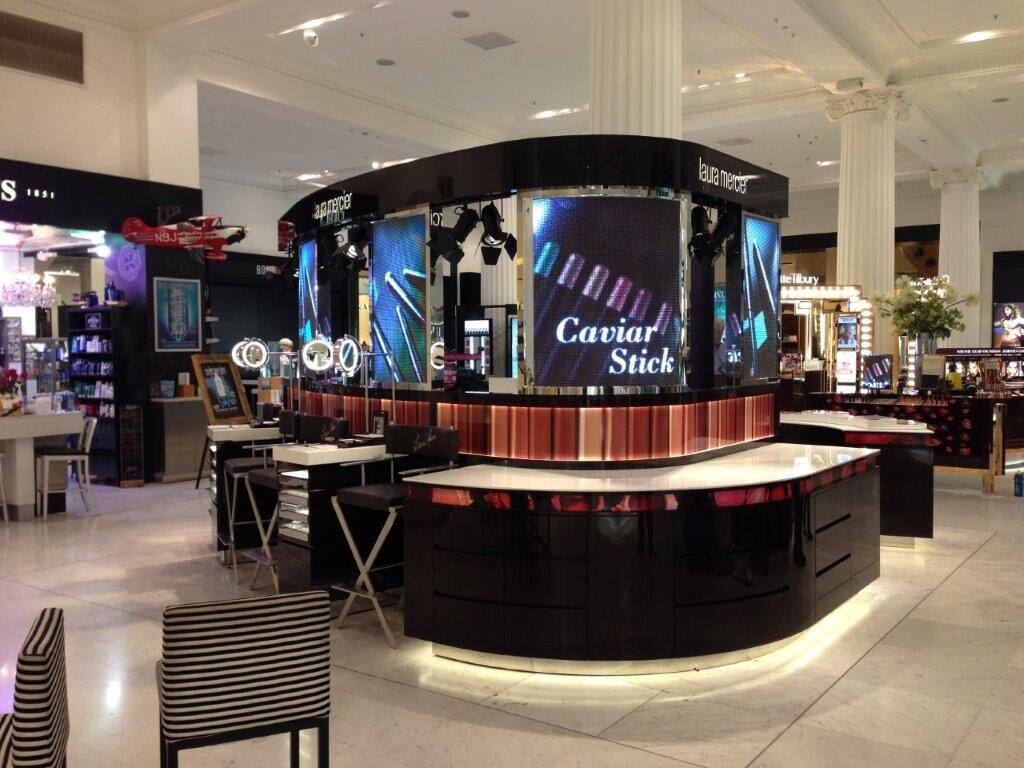 Black circular beauty counter with illuminated Caviar Stick branding