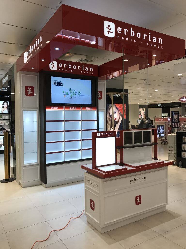 Erborian brand space in deep red with illuminated shelving