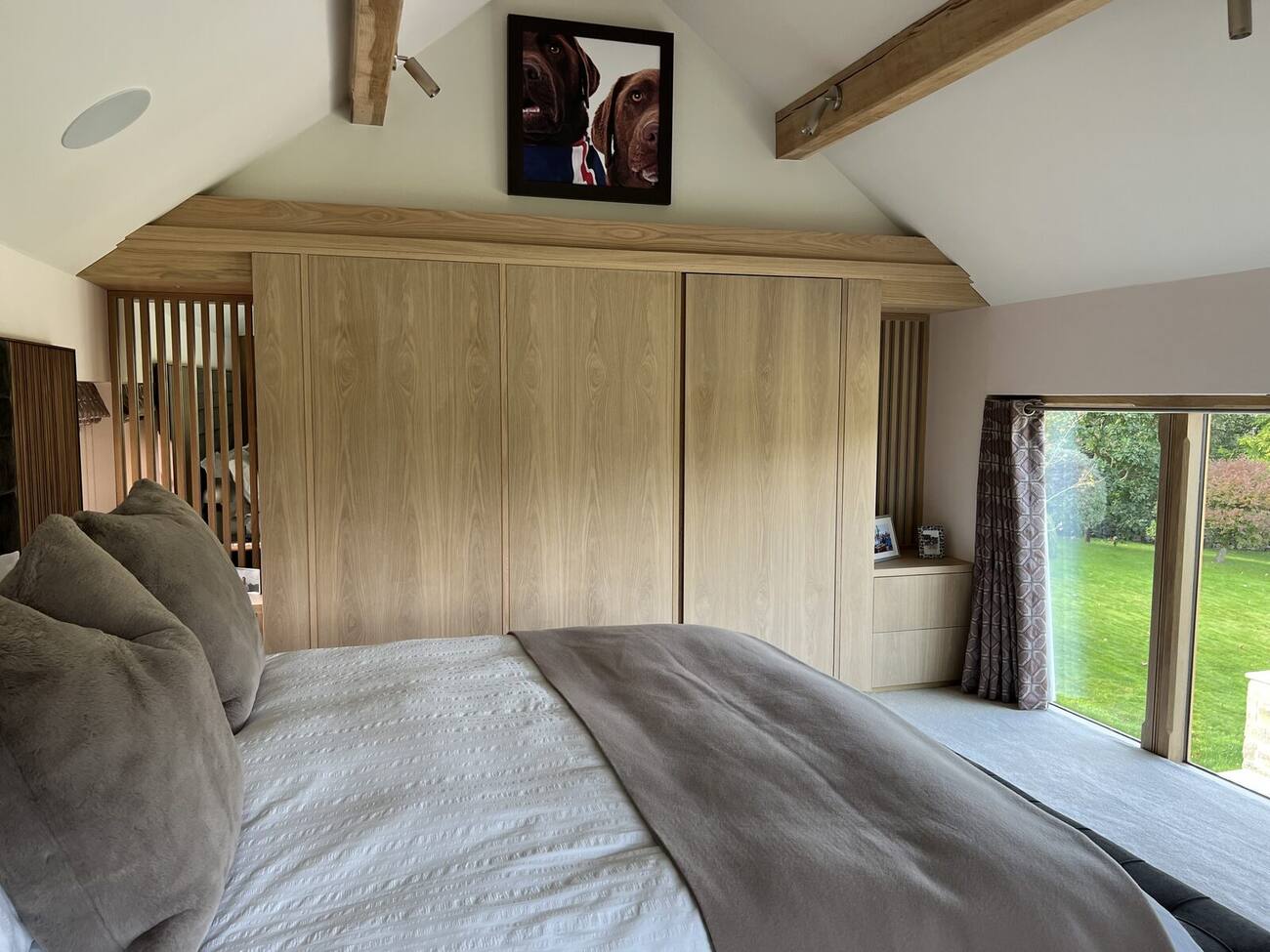Fitted oak wardrobes in a vaulted bedroom