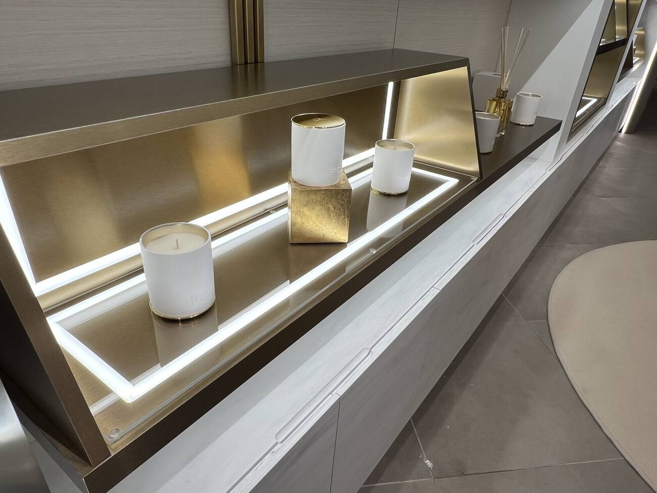 Illuminated luxury perfumery display table with brass base, Harrods